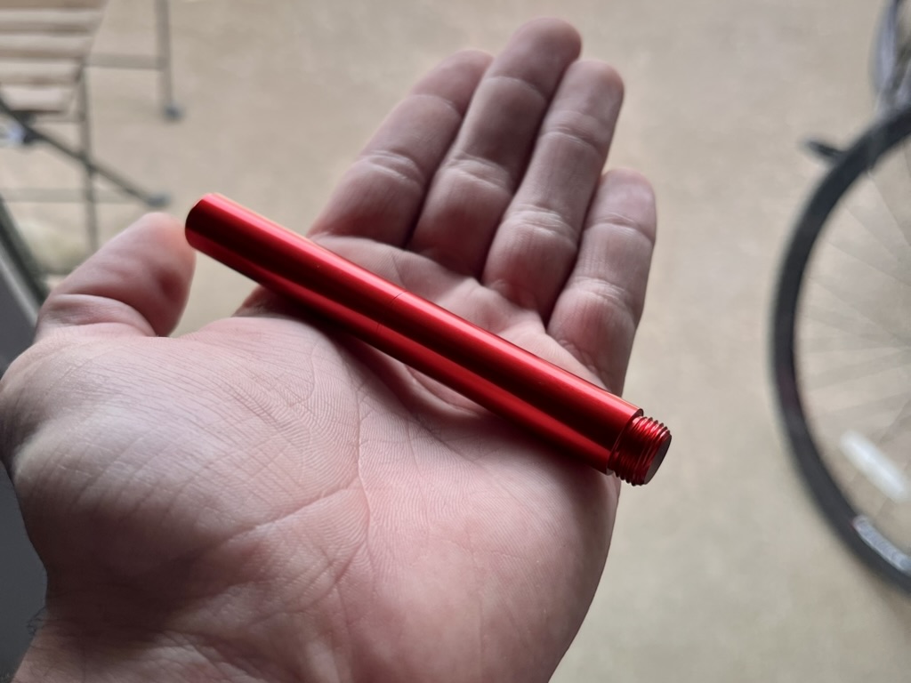 Red fountain pen resting in the author's hand